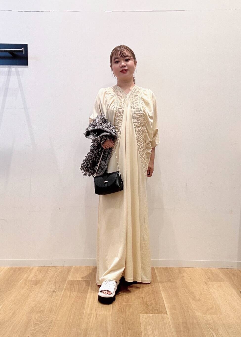 ブラック系のショルダーバッグ、ホワイト系のワンピース、グレー系のベストを着用したレディースの夏コーディネートの4枚目の写真