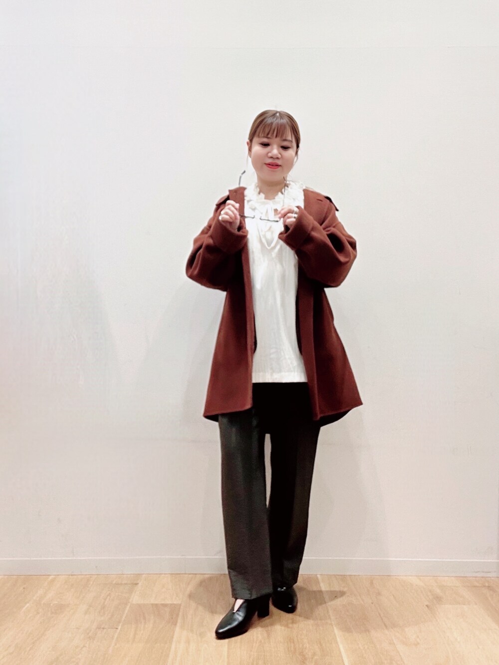 ブラウン系のステンカラーコート、ブラック系のパンプス、グリーン系のその他パンツを着用したレディースの秋コーディネートの2枚目の写真