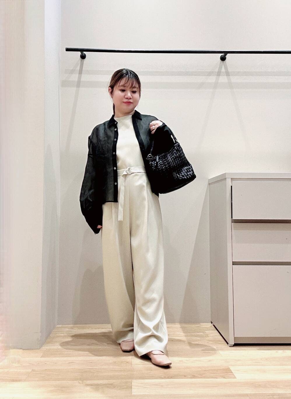 ベージュ系のサロペット/オーバーオール、ベージュ系のパンプス、ブラック系のシャツ/ブラウスを着用したレディースの春コーディネートの3枚目の写真