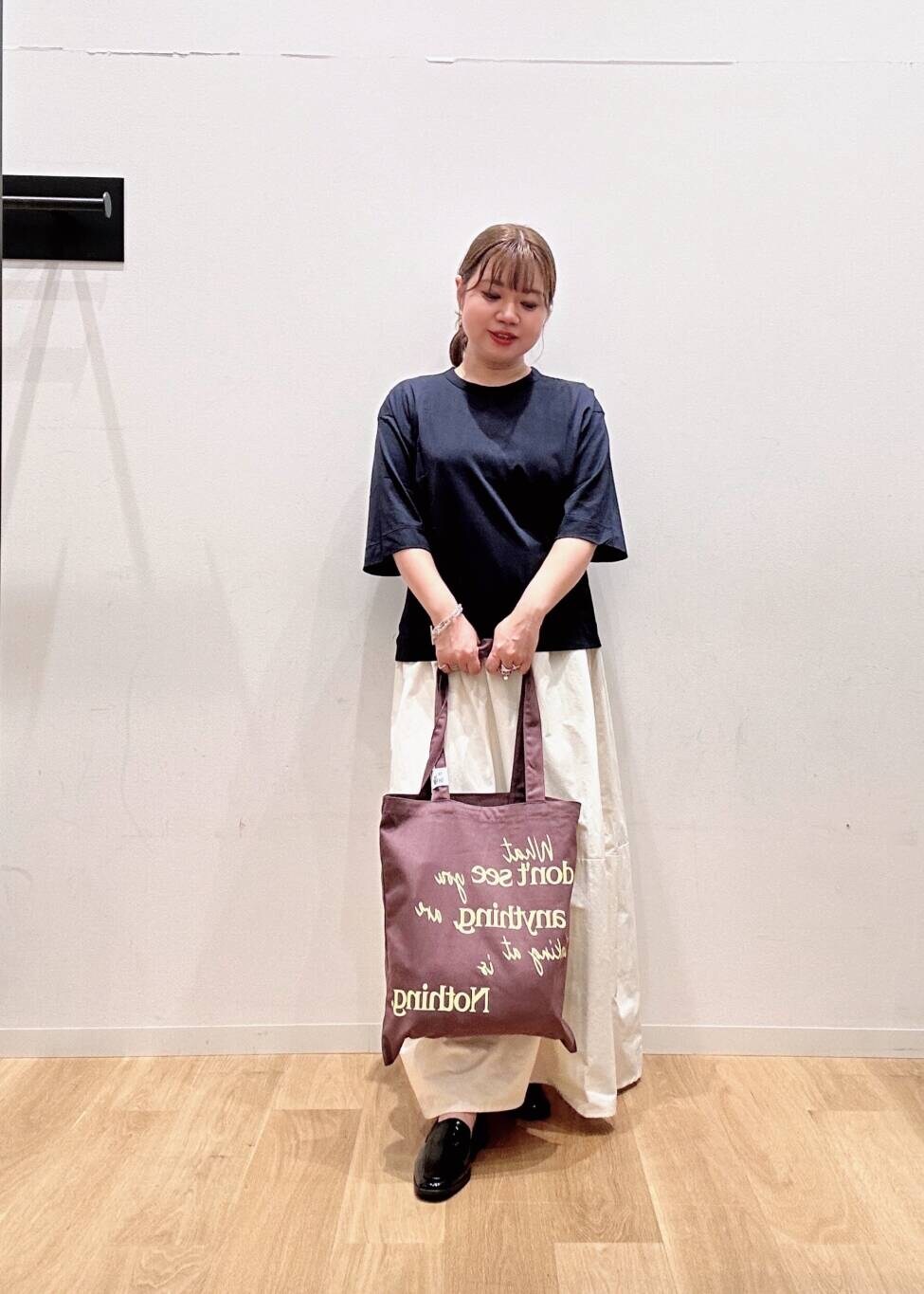 ホワイト系のスカート、ブラック系のローファー、ブルー系のTシャツ/カットソーを着用したレディースの夏コーディネートの3枚目の写真