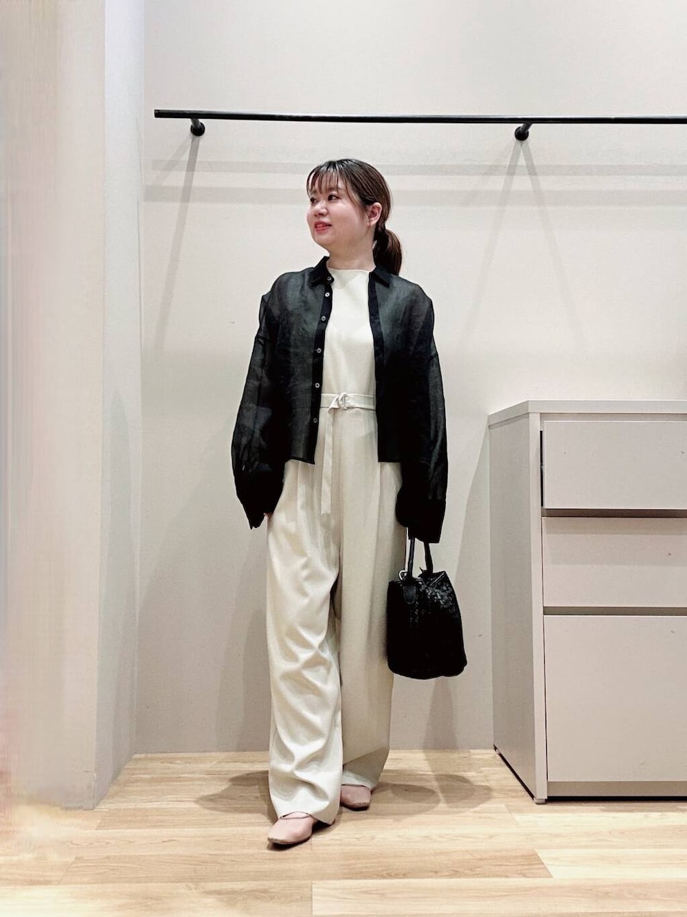 ベージュ系のサロペット/オーバーオール、ベージュ系のパンプス、ブラック系のシャツ/ブラウスを着用したレディースの春コーディネートの2枚目の写真