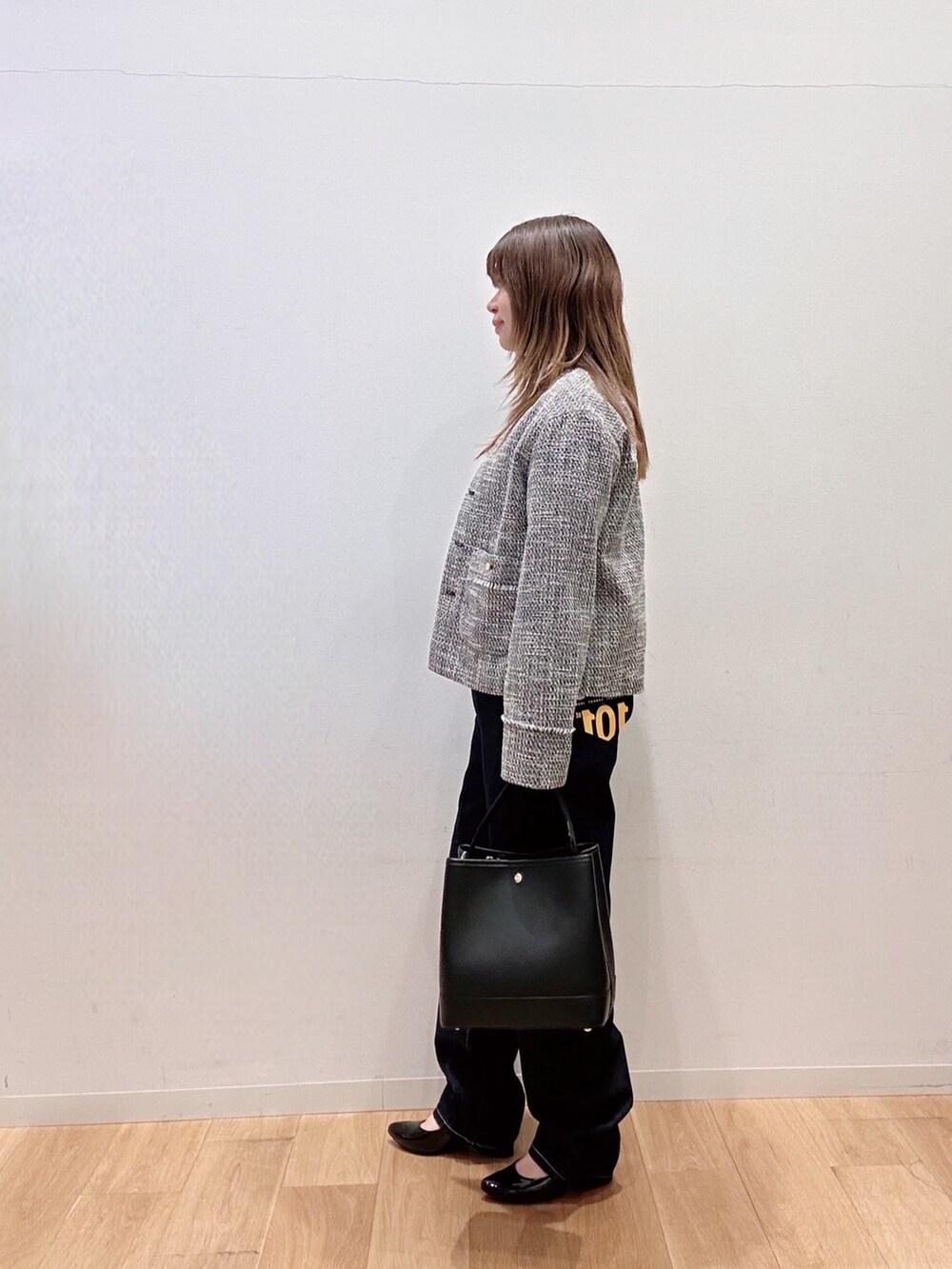 ブラック系のノーカラージャケット、ブルー系のデニムパンツ、ブラック系のハンドバッグを着用したレディースの冬コーディネートの4枚目の写真