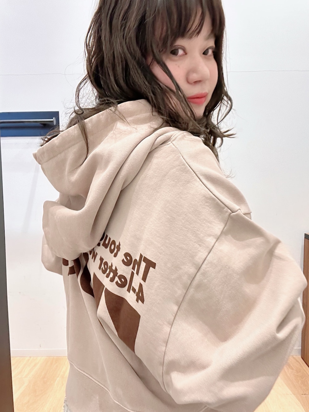 ホワイト系のスカート、グレー系のデニムパンツ、ベージュ系のパーカーを着用したレディースの冬コーディネートの4枚目の写真