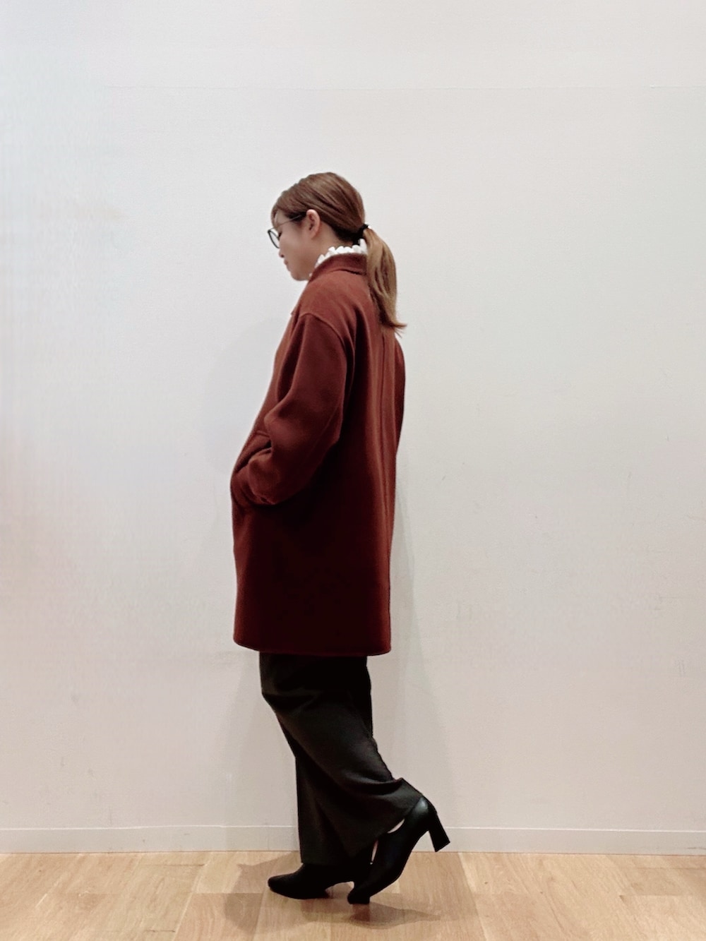 ブラウン系のステンカラーコート、ブラック系のパンプス、グリーン系のその他パンツを着用したレディースの秋コーディネートの3枚目の写真