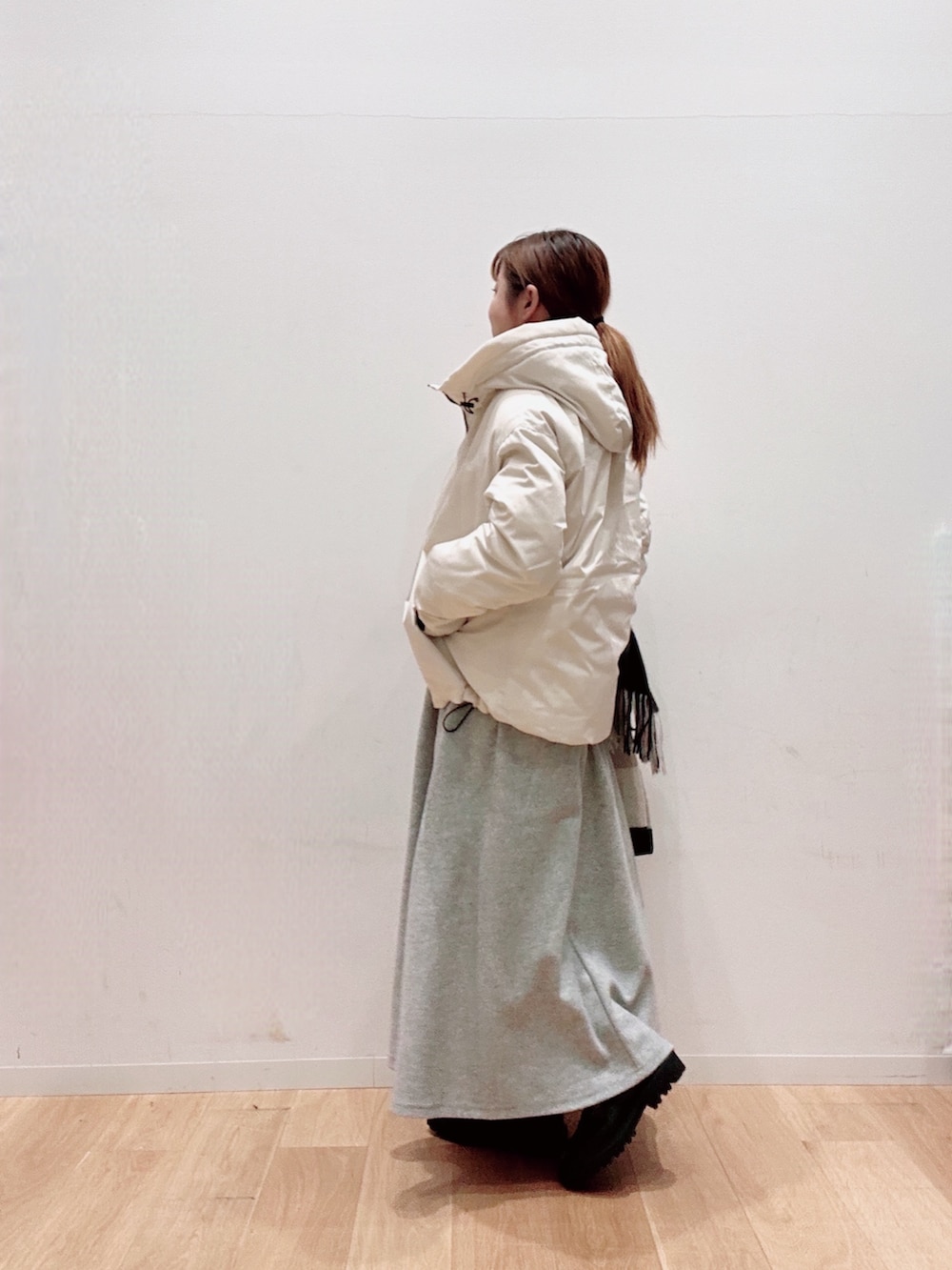 ホワイト系のカーディガン/ボレロ、ホワイト系のダウンジャケット/コート、グレー系のスカートを着用したレディースの秋コーディネートの3枚目の写真