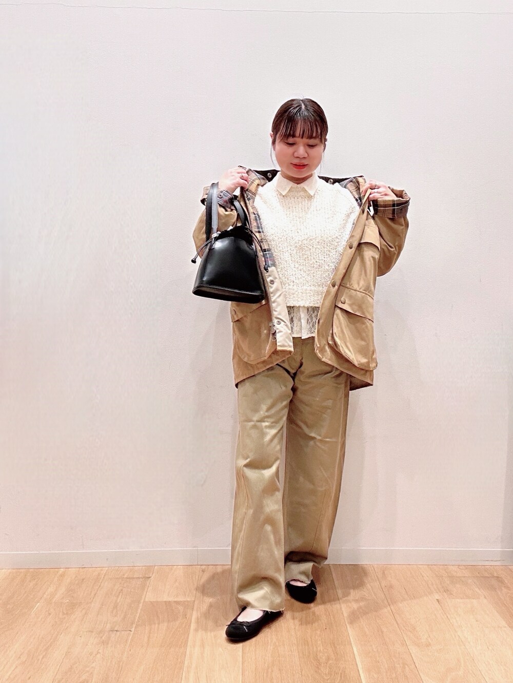 ブラック系のバレエシューズ、ベージュ系のその他パンツ、ホワイト系のニット/セーターを着用したレディースの冬コーディネートの3枚目の写真