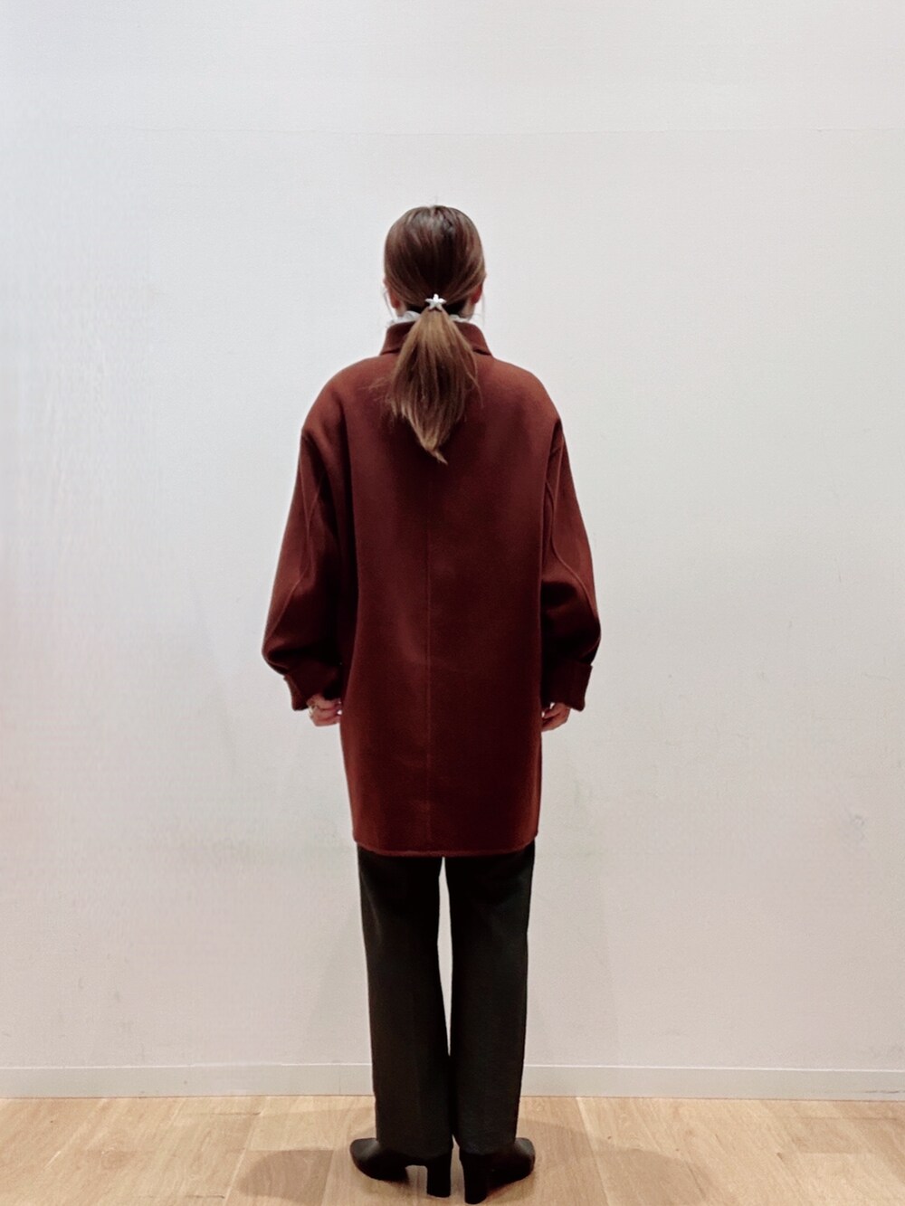 ブラウン系のステンカラーコート、ブラック系のパンプス、グリーン系のその他パンツを着用したレディースの秋コーディネートの5枚目の写真