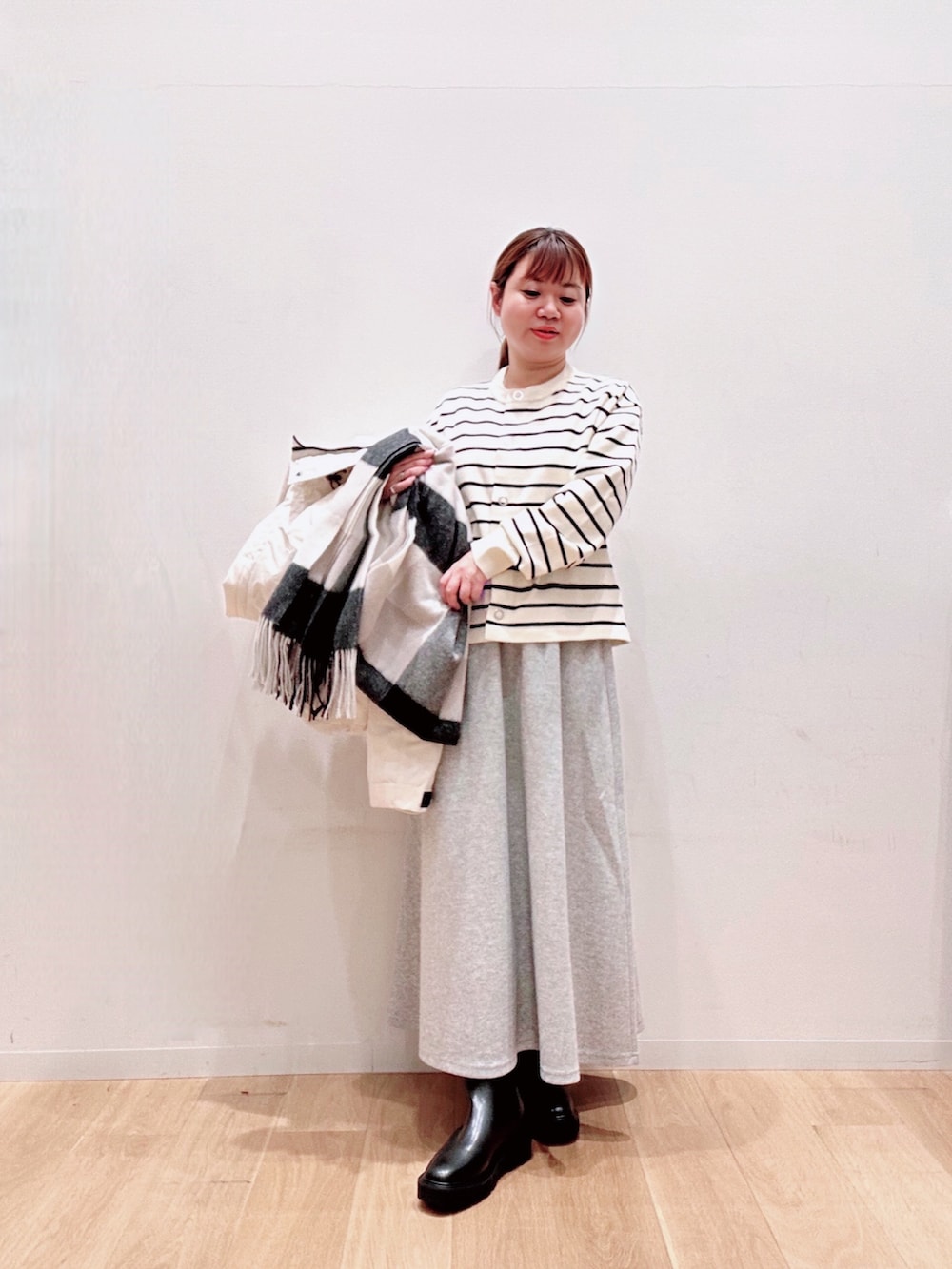 ホワイト系のカーディガン/ボレロ、ホワイト系のダウンジャケット/コート、グレー系のスカートを着用したレディースの秋コーディネートの4枚目の写真