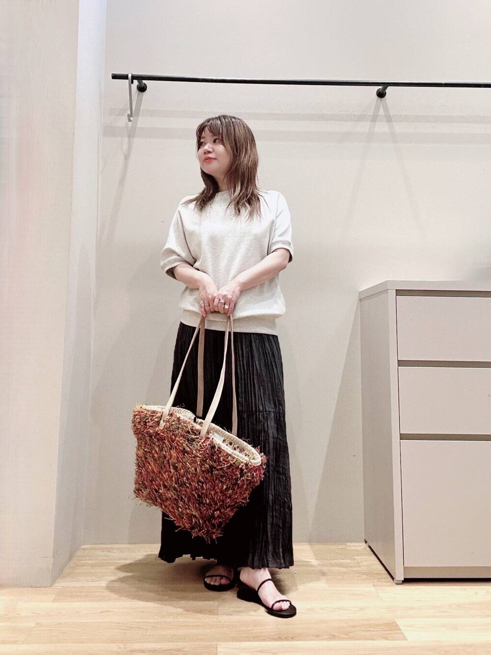 グレー系のスカート、ブラック系のサンダル、グレー系のTシャツ/カットソーを着用したレディースの春コーディネートの3枚目の写真