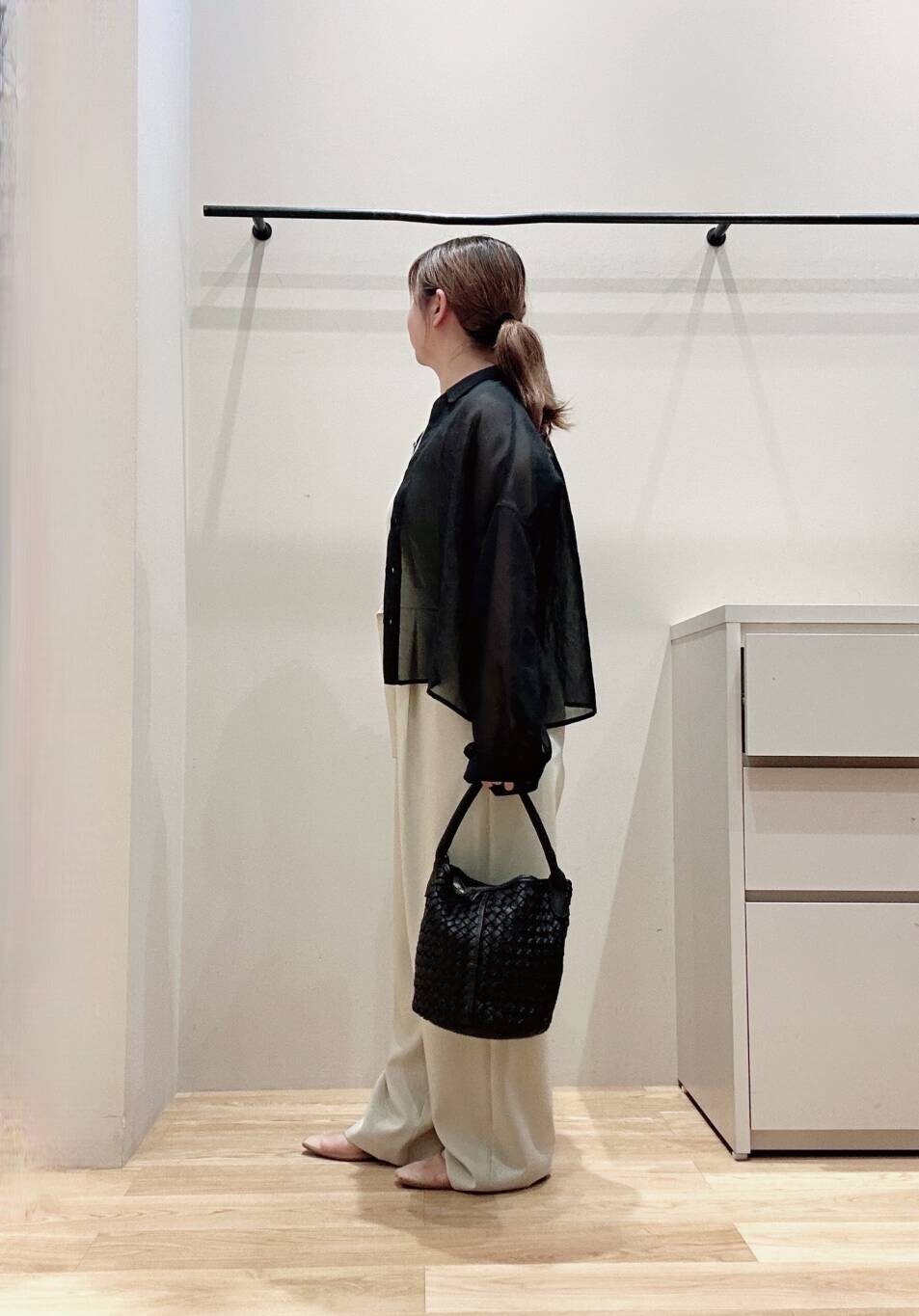 ベージュ系のサロペット/オーバーオール、ベージュ系のパンプス、ブラック系のシャツ/ブラウスを着用したレディースの春コーディネートの5枚目の写真