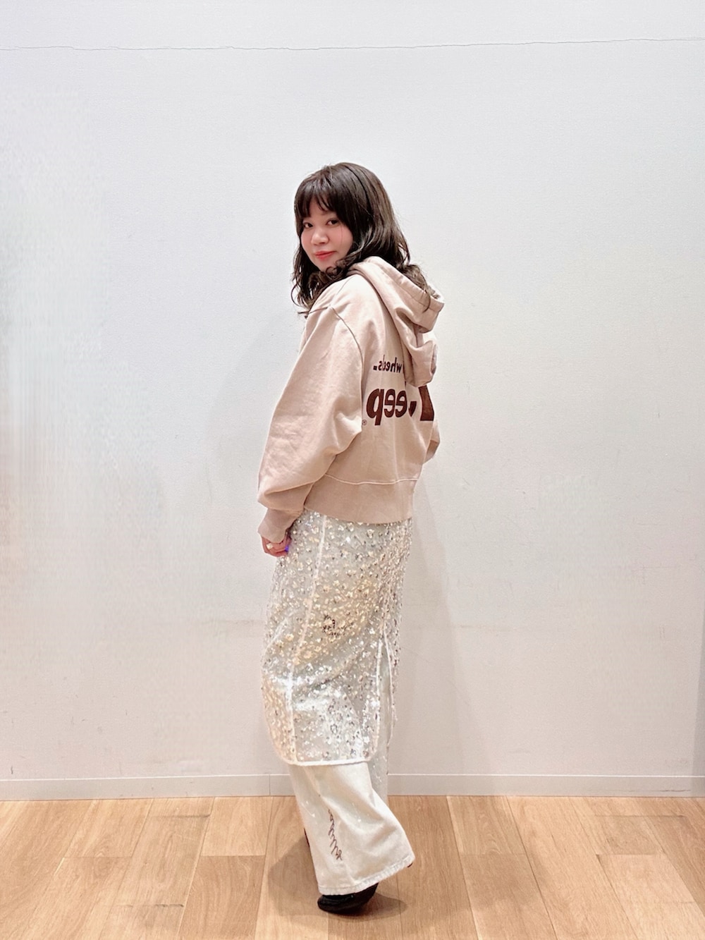 ホワイト系のスカート、グレー系のデニムパンツ、ベージュ系のパーカーを着用したレディースの冬コーディネートの2枚目の写真