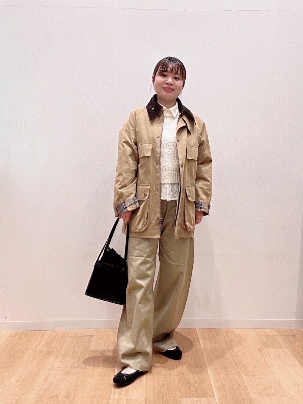 ブラック系のバレエシューズ、ベージュ系のその他パンツ、ホワイト系のニット/セーターを着用したレディースの冬コーディネートの2枚目の写真