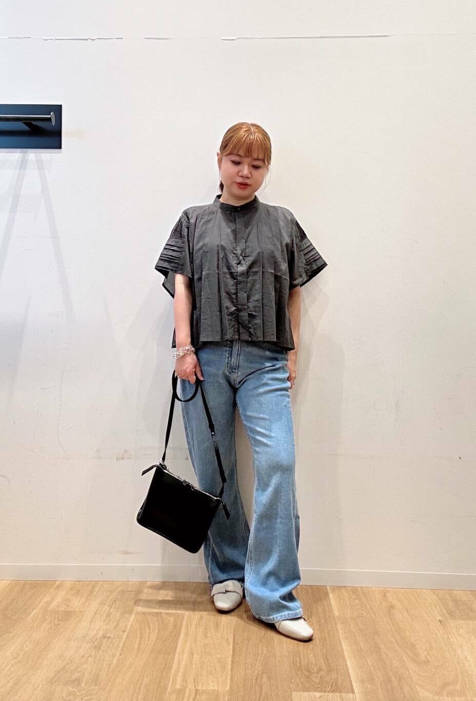 グレー系のドレスシューズ、ブルー系のデニムパンツ、グレー系のシャツ/ブラウスを着用したレディースの夏コーディネートの2枚目の写真