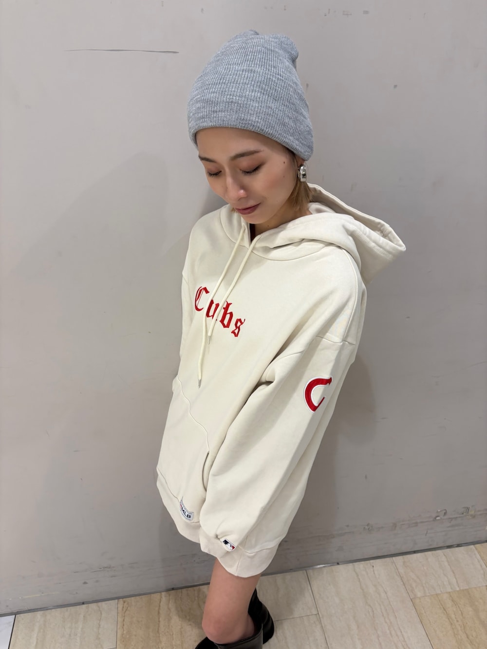 ホワイト系のパーカー、ブラック系のブーツを着用したレディースの冬コーディネートの2枚目の写真