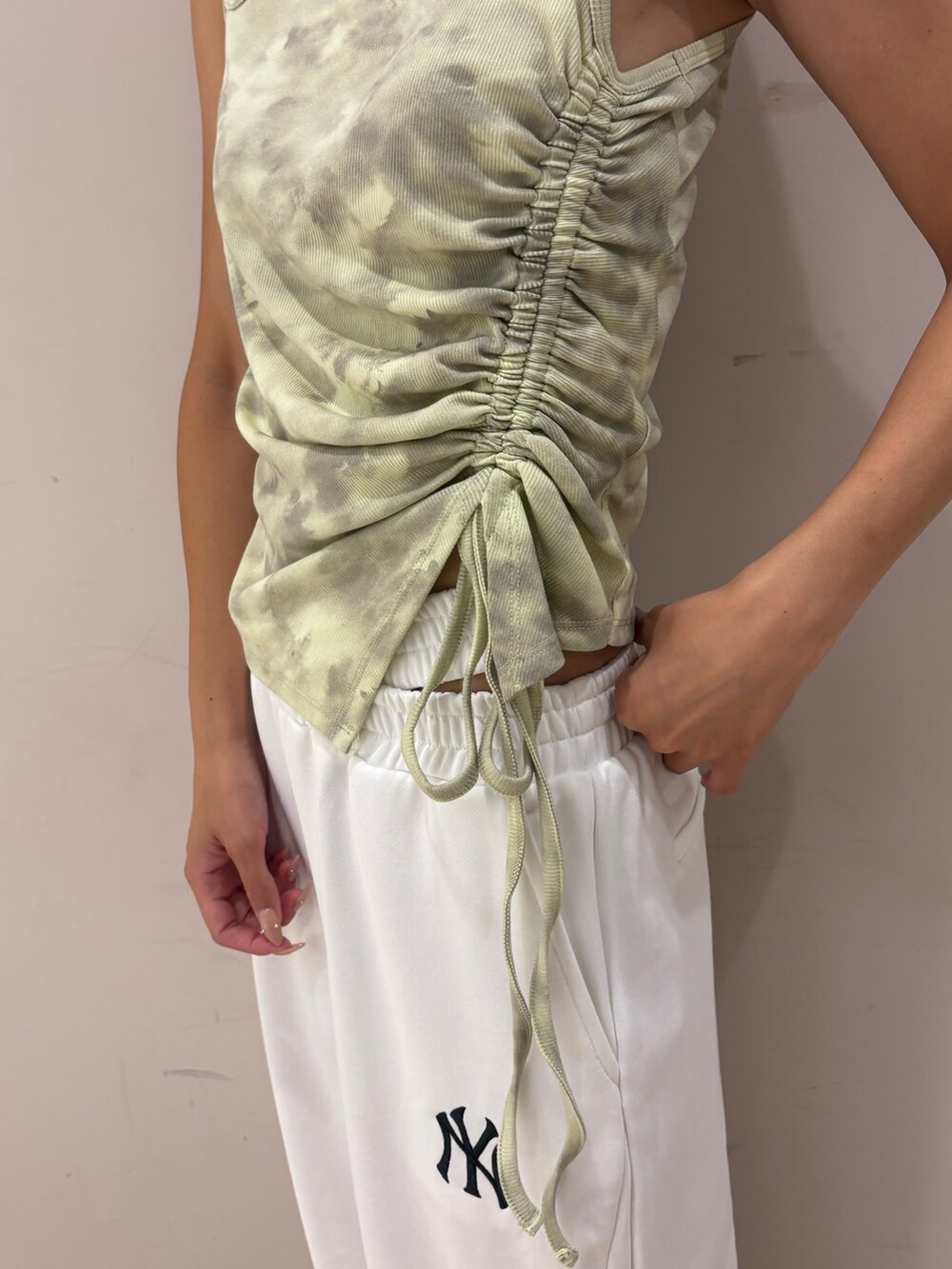 ホワイト系のスウェットパンツ、グリーン系のタンクトップを着用したレディースの夏コーディネートの3枚目の写真