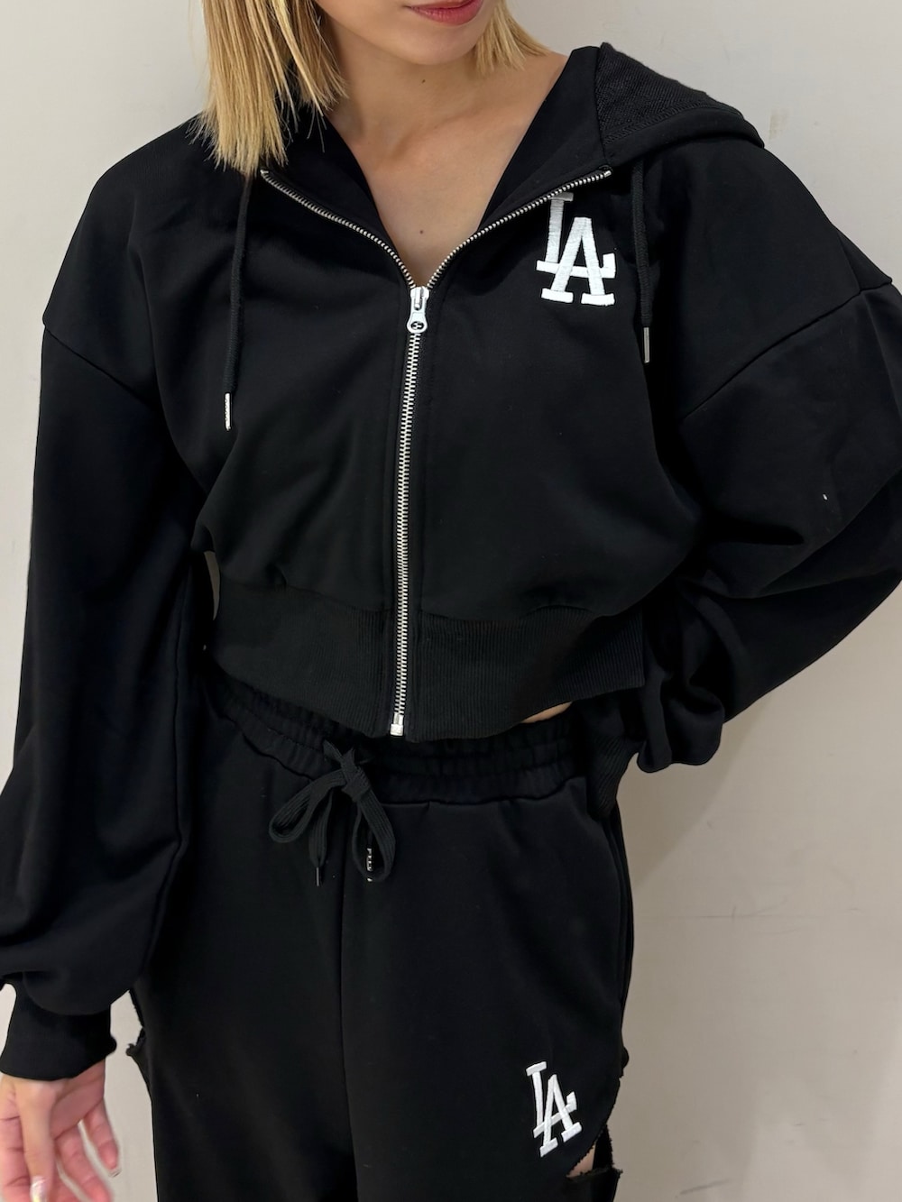 ブラック系のスウェットパンツ、ブラック系のパーカーを着用したレディースの秋コーディネートの2枚目の写真