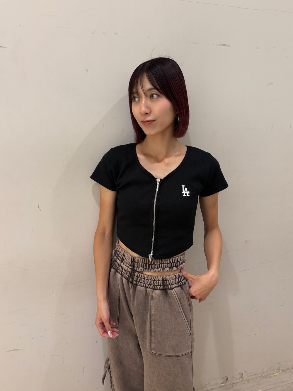 ブラウン系のスウェットパンツ、ブラック系のTシャツ/カットソー、レッド系のハンドバッグを着用したレディースの夏コーディネートの2枚目の写真