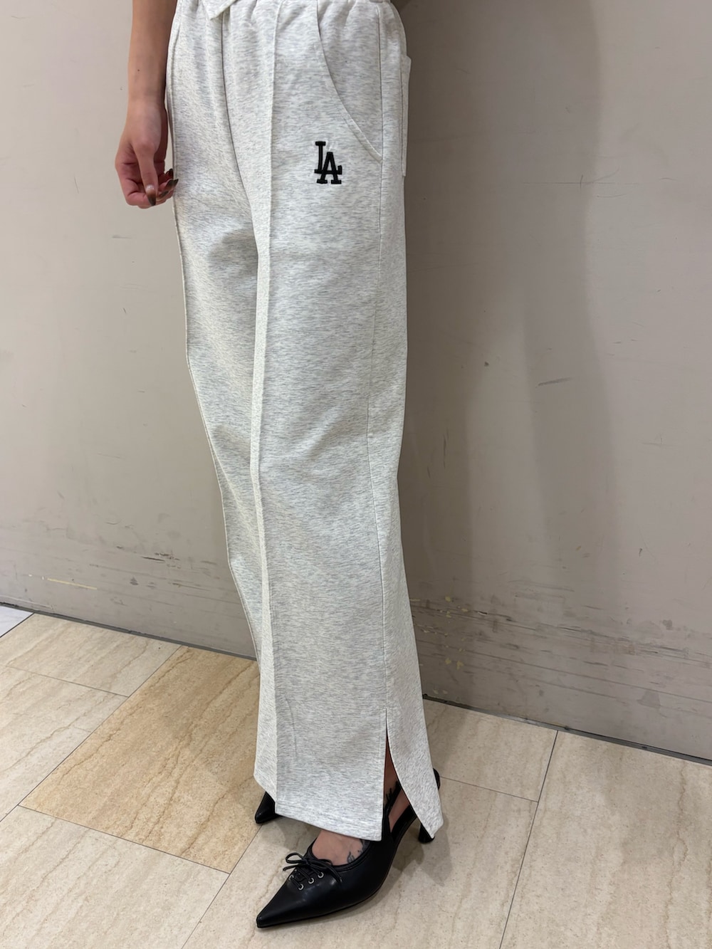 グレー系のワンピース、ブラック系のパンプス、ブラック系のキャップを着用したレディースの春コーディネートの7枚目の写真