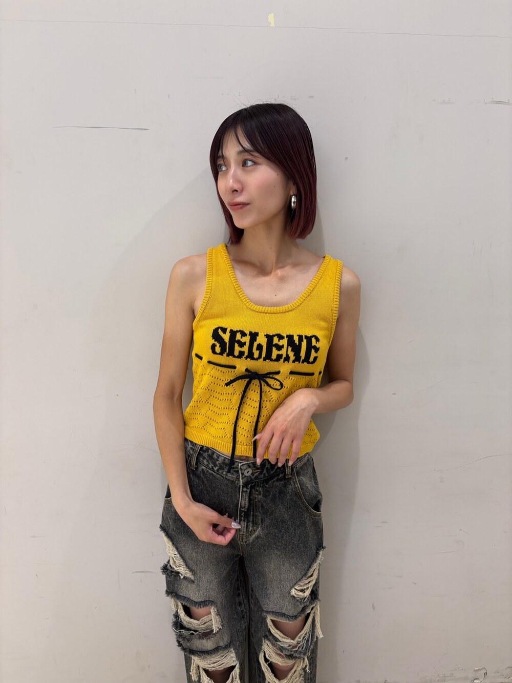 ブラック系のデニムパンツ、ブラック系のパンプス、ホワイト系のチューブトップを着用したレディースの夏コーディネートの2枚目の写真