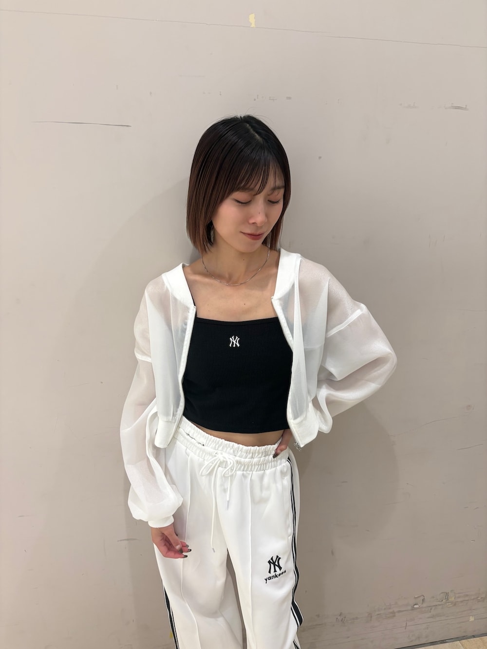 ホワイト系のその他パンツ、ホワイト系のブルゾン、ブラック系のキャミソールを着用したレディースの春コーディネートの2枚目の写真