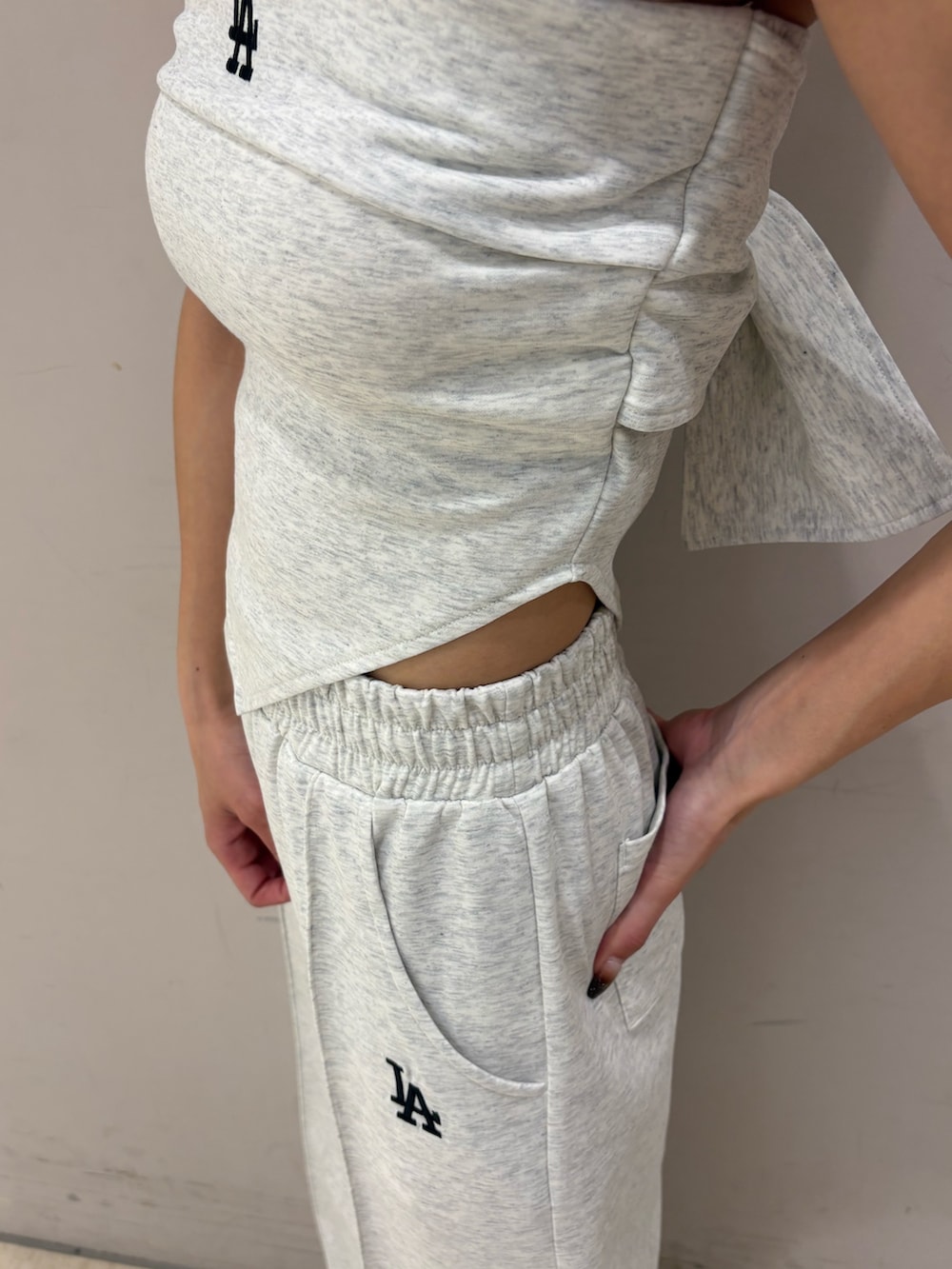 グレー系のワンピース、ブラック系のパンプス、ブラック系のキャップを着用したレディースの春コーディネートの6枚目の写真