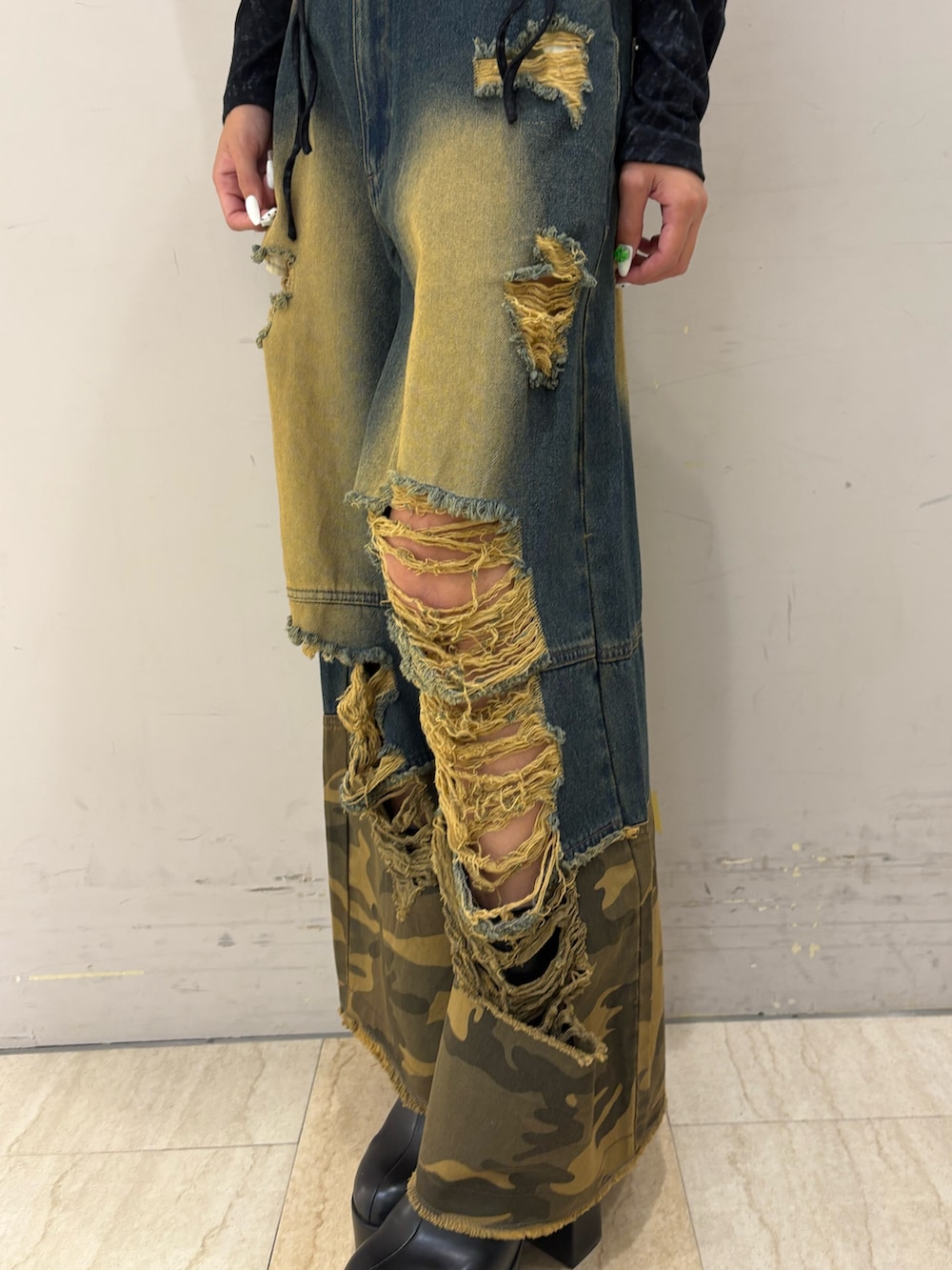 ブルー系のデニムパンツ、ブラック系のTシャツ/カットソー、ブラック系のブーツを着用したレディースの秋コーディネートの3枚目の写真