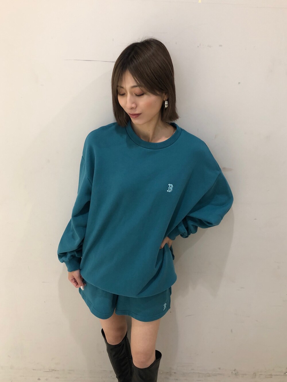 グリーン系のワンピース、ブラック系のブーツを着用したレディースの夏コーディネートの2枚目の写真