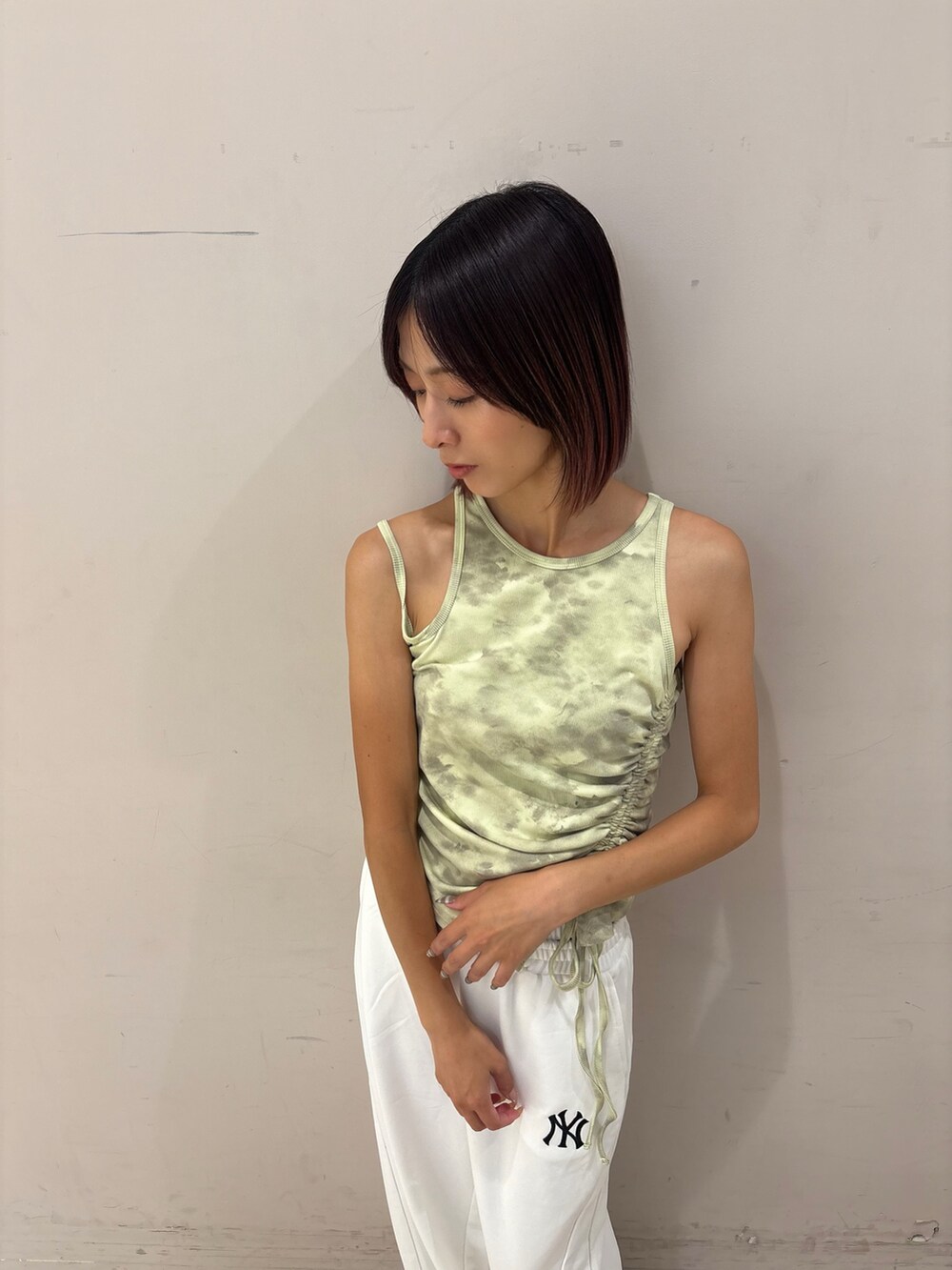 ホワイト系のスウェットパンツ、グリーン系のタンクトップを着用したレディースの夏コーディネートの2枚目の写真