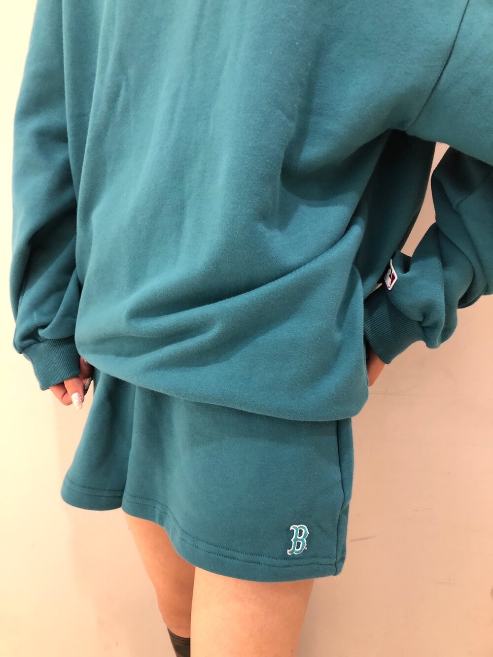 グリーン系のワンピース、ブラック系のブーツを着用したレディースの夏コーディネートの4枚目の写真