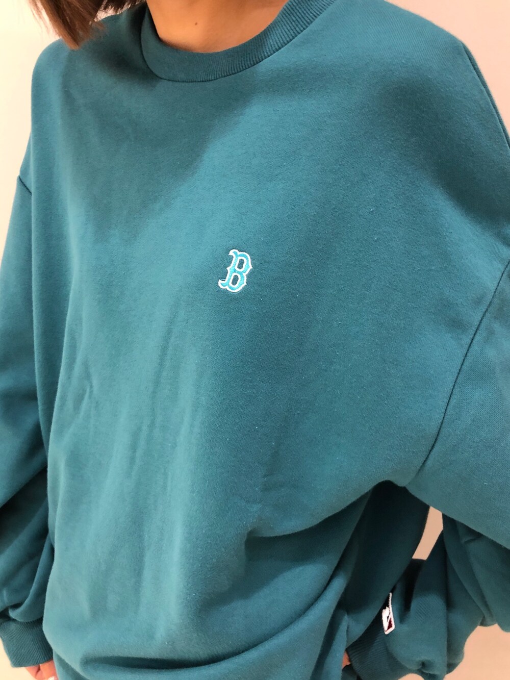 グリーン系のワンピース、ブラック系のブーツを着用したレディースの夏コーディネートの3枚目の写真