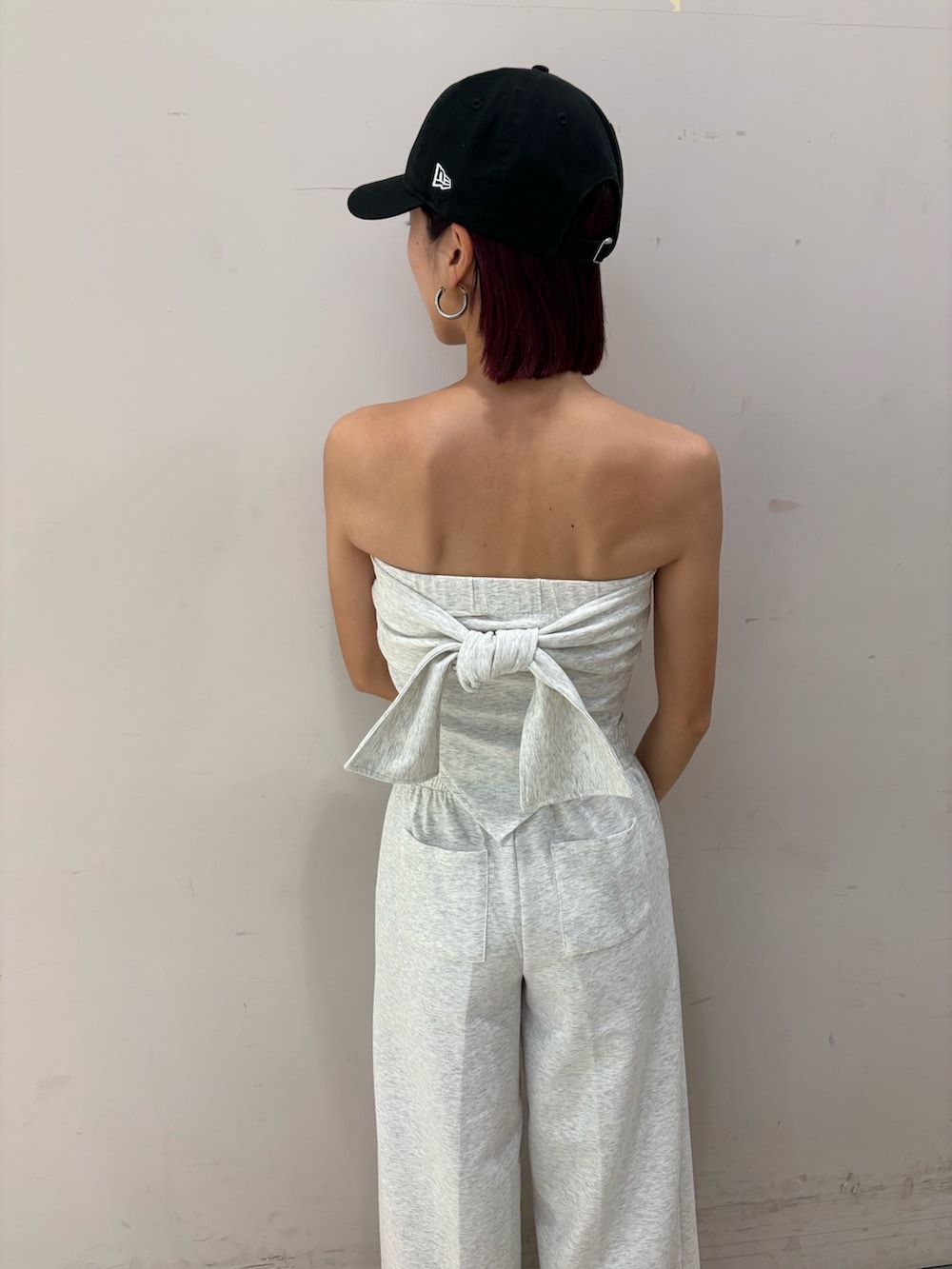 グレー系のワンピース、ブラック系のパンプス、ブラック系のキャップを着用したレディースの春コーディネートの4枚目の写真