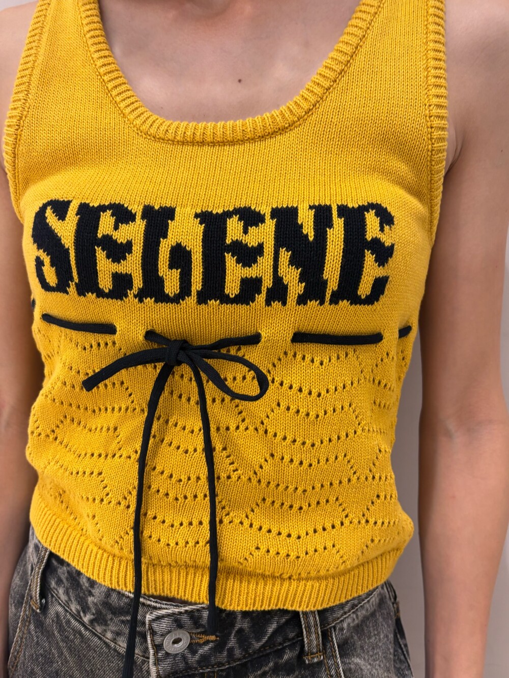 ブラック系のデニムパンツ、ブラック系のパンプス、ホワイト系のチューブトップを着用したレディースの夏コーディネートの3枚目の写真