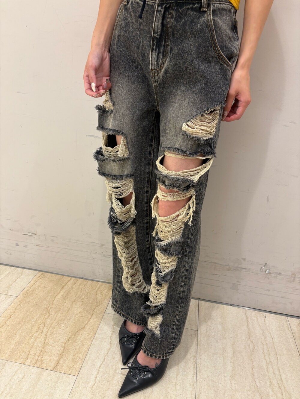 ブラック系のデニムパンツ、ブラック系のパンプス、ホワイト系のチューブトップを着用したレディースの夏コーディネートの4枚目の写真