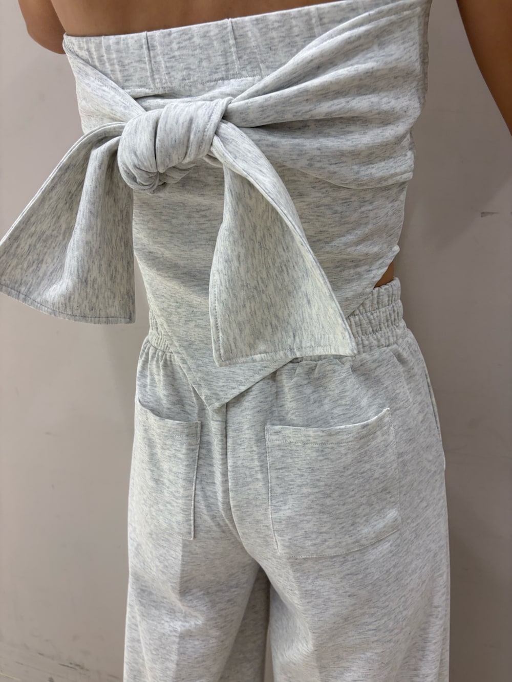 グレー系のワンピース、ブラック系のパンプス、ブラック系のキャップを着用したレディースの春コーディネートの5枚目の写真