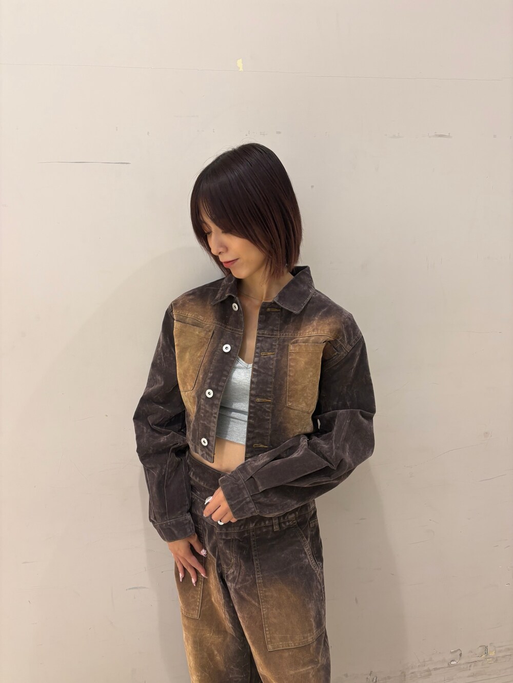 ブラウン系のデニムパンツ、ブラウン系のデニムジャケット、グレー系のキャミソールを着用したレディースの秋コーディネートの2枚目の写真