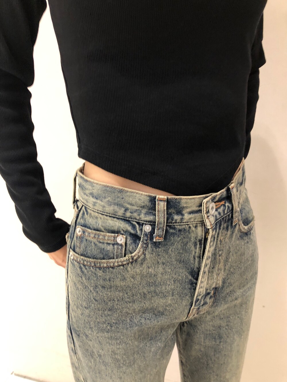 ブルー系のデニムパンツ、ブラック系のTシャツ/カットソーを着用したレディースの秋コーディネートの4枚目の写真