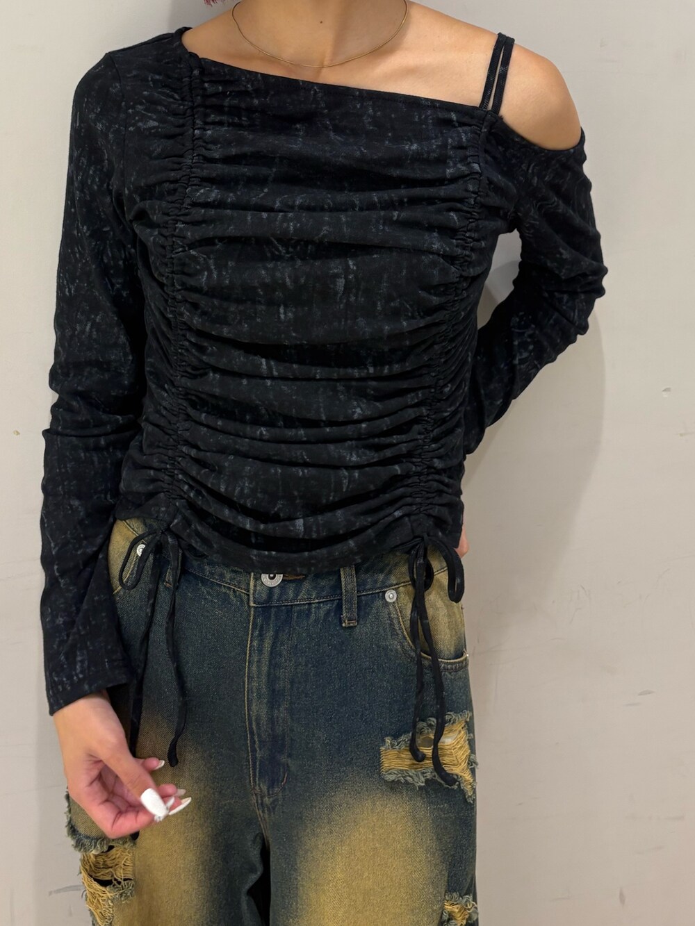 ブルー系のデニムパンツ、ブラック系のTシャツ/カットソー、ブラック系のブーツを着用したレディースの秋コーディネートの2枚目の写真