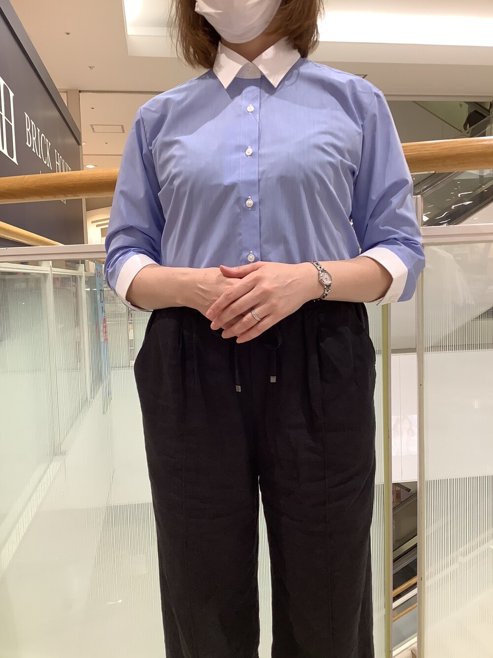 ブルー系のビジネスシャツを着用したレディースの秋コーディネートの2枚目の写真