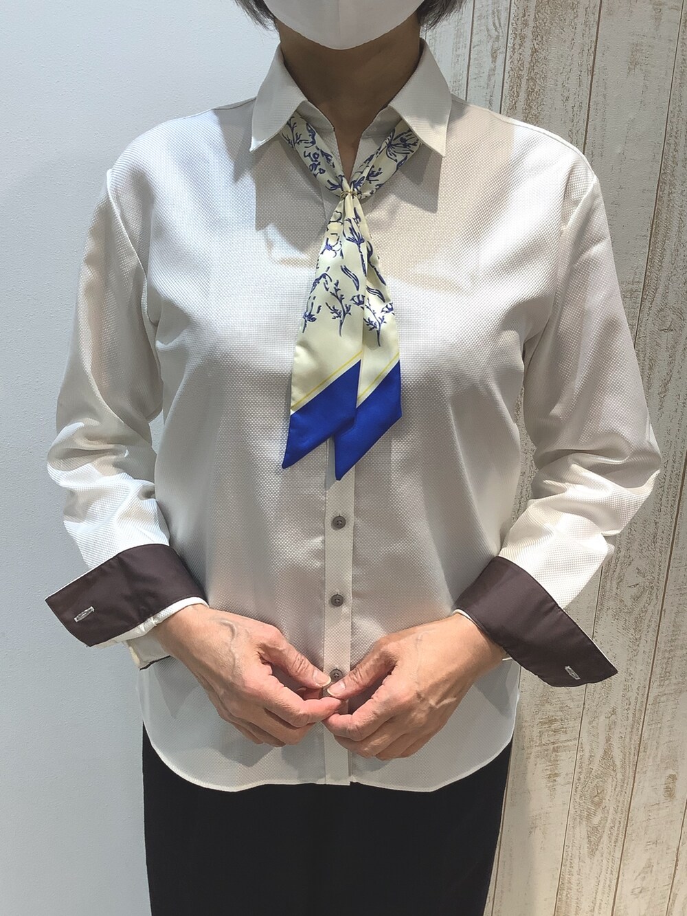 イエロー系のビジネスシャツを着用したレディースの冬コーディネートの2枚目の写真