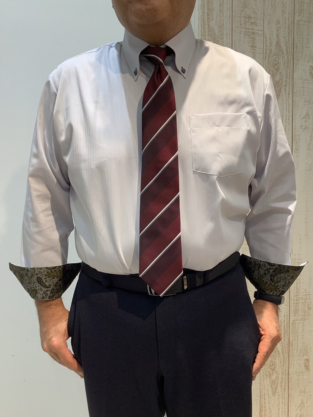 グレー系のビジネスシャツ、レッド系のネクタイを着用したメンズの冬コーディネートの2枚目の写真