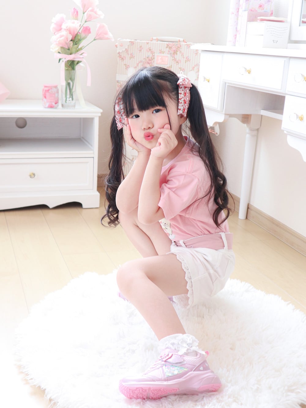 ピンク系のトップス、ピンク系のスニーカー、ホワイト系のパンツを着用したキッズの春コーディネートの3枚目の写真