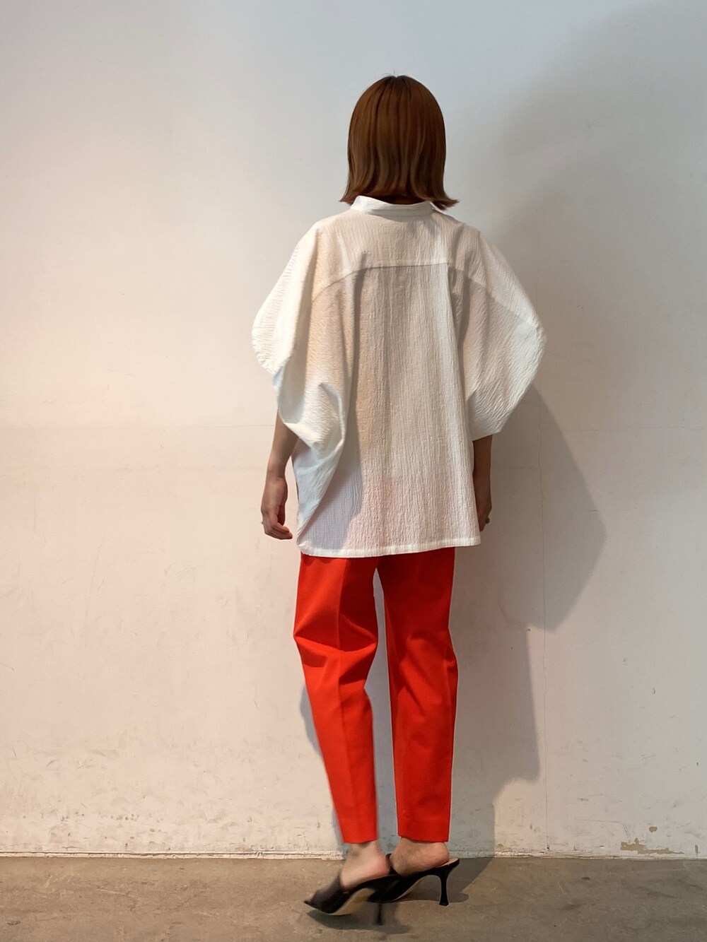 レッド系のその他パンツ、ホワイト系のシャツ/ブラウス、ブラック系のサンダルを着用したレディースの春コーディネートの4枚目の写真