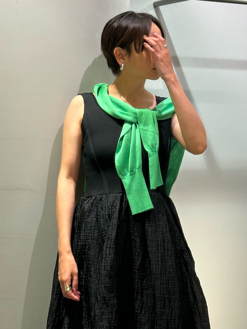 ブラック系のワンピース、ブラック系のサンダル、グリーン系のカーディガン/ボレロを着用したレディースの夏コーディネートの7枚目の写真