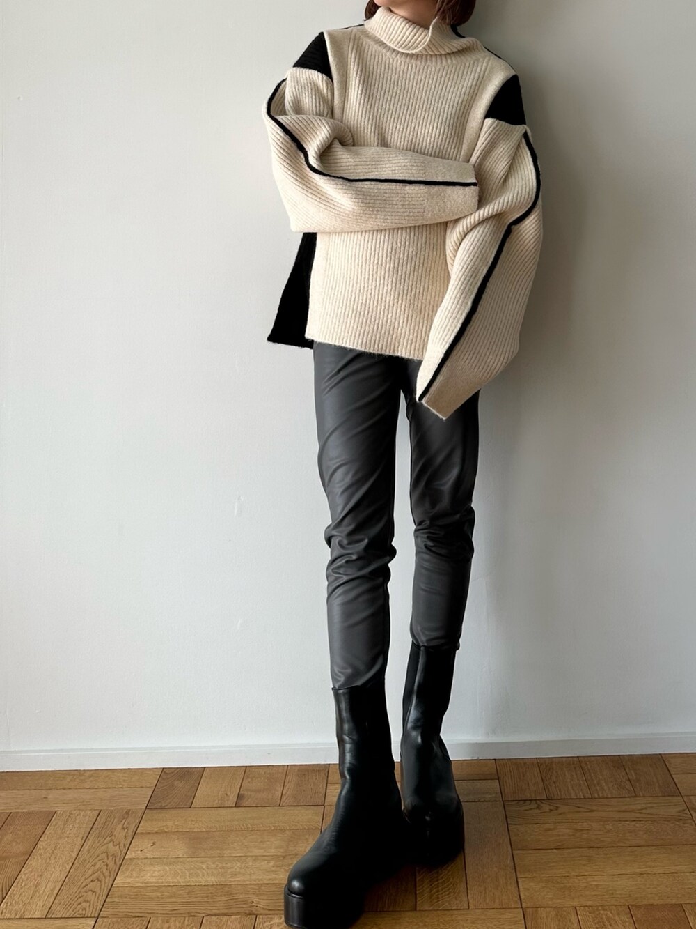 ホワイト系のニット/セーター、グレー系のその他パンツ、ブラック系のブーツを着用したレディースの秋コーディネートの3枚目の写真