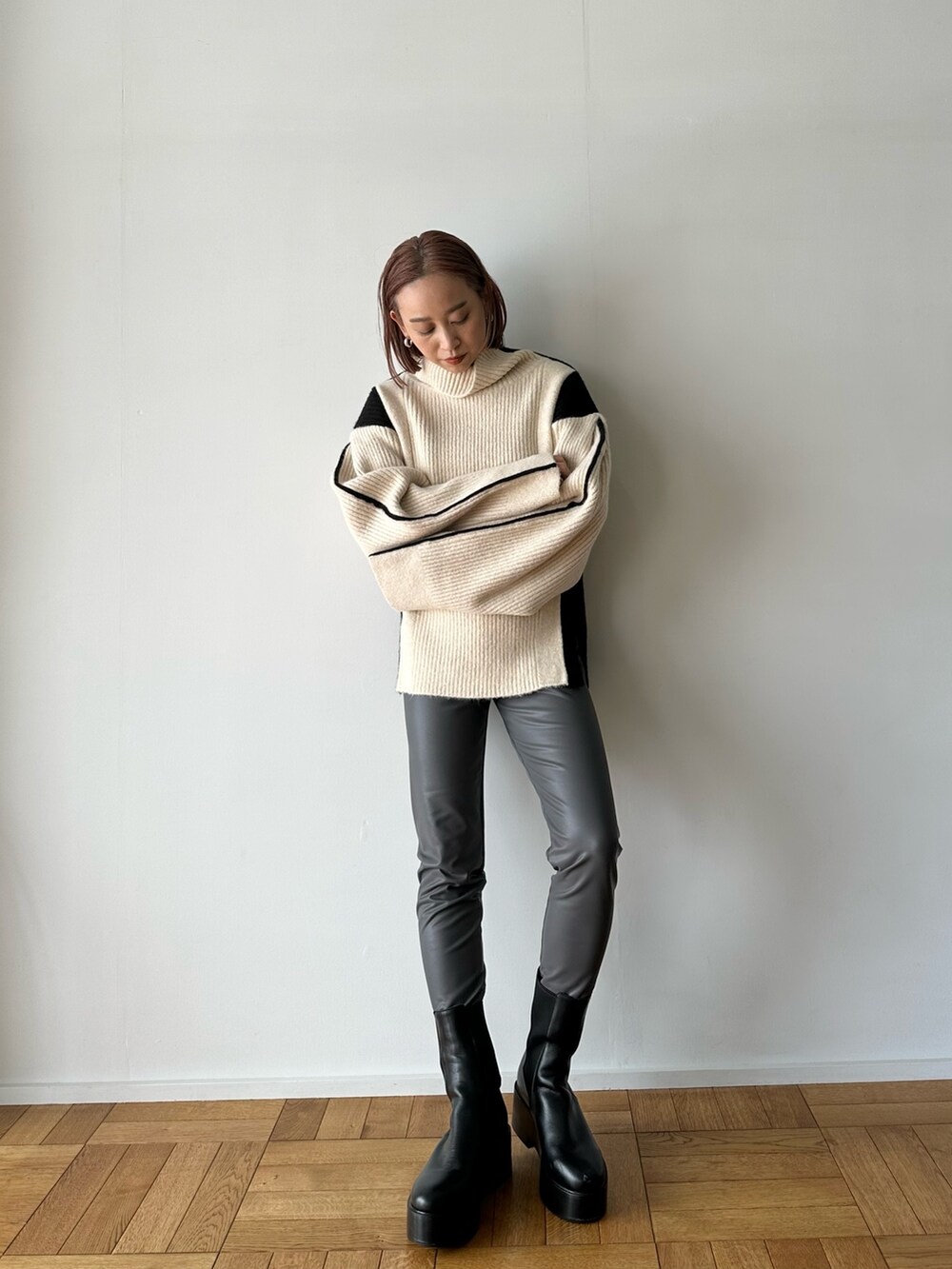 ホワイト系のニット/セーター、グレー系のその他パンツ、ブラック系のブーツを着用したレディースの秋コーディネートの2枚目の写真