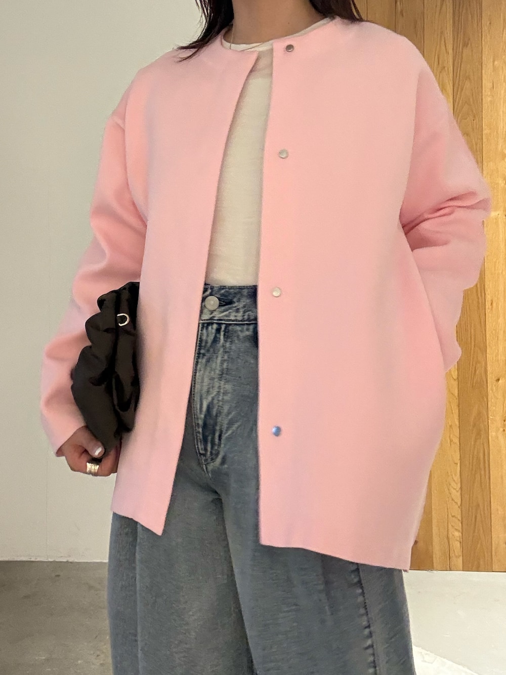 ブルー系のデニムパンツ、ブラック系のパンプス、ピンク系のカーディガン/ボレロを着用したレディースの冬コーディネートの5枚目の写真