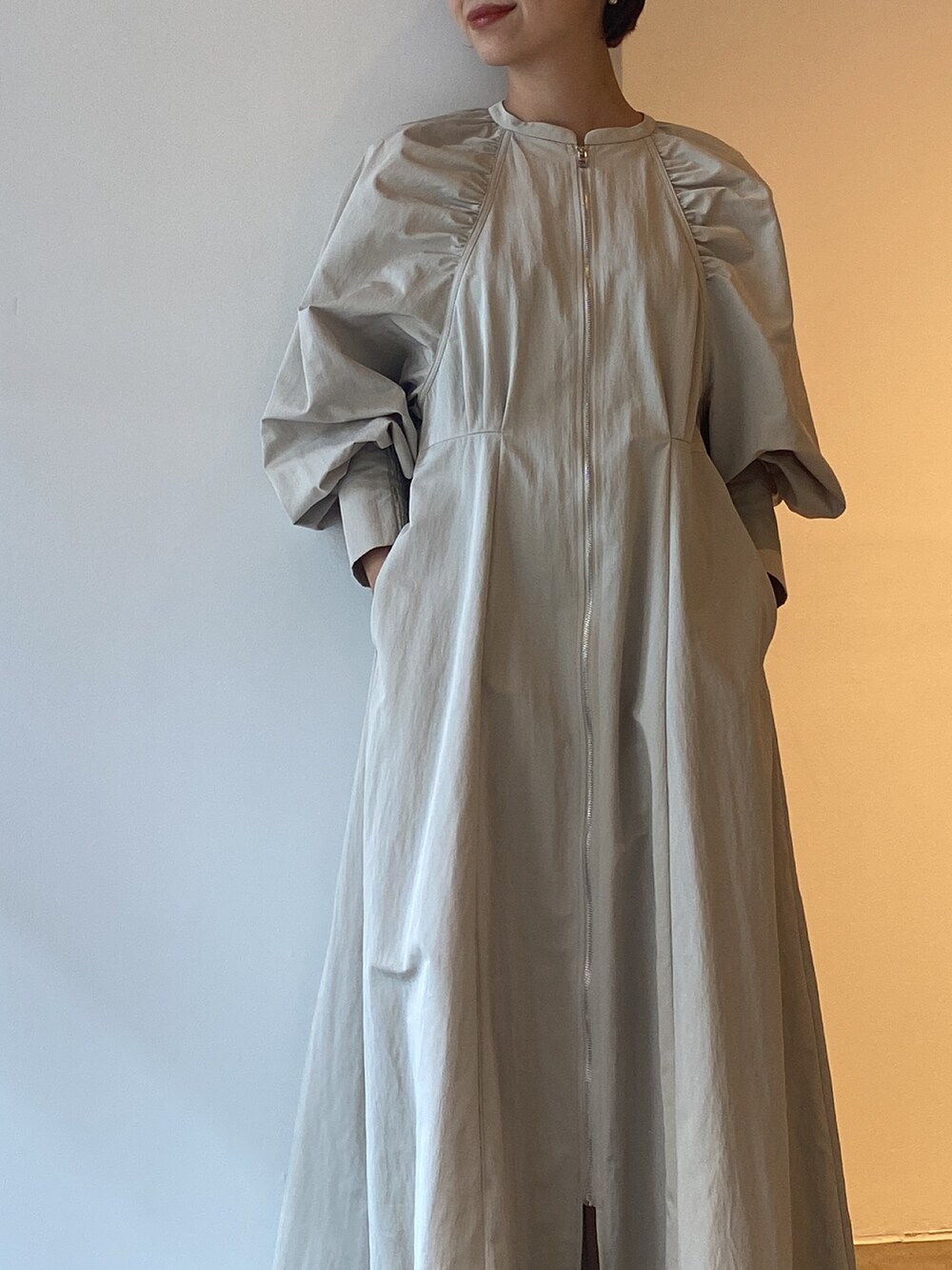 シルバー系のボストンバッグ、ブラック系のブーツ、ベージュ系のワンピースを着用したレディースの冬コーディネートの10枚目の写真