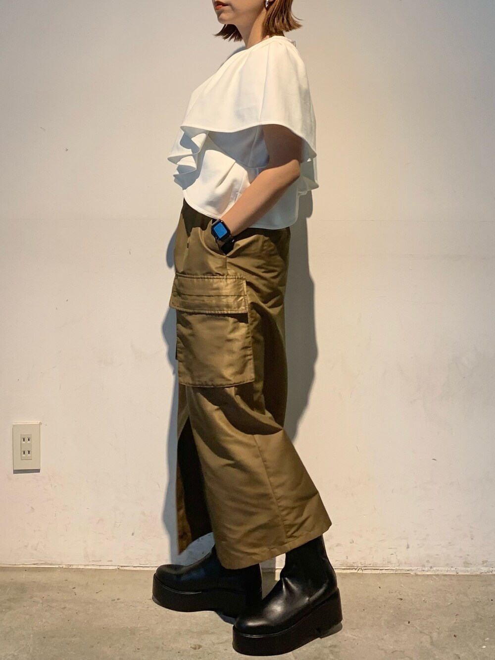 ホワイト系のTシャツ/カットソー、ブラウン系のスカート、ブラック系のブーツを着用したレディースの春コーディネートの4枚目の写真