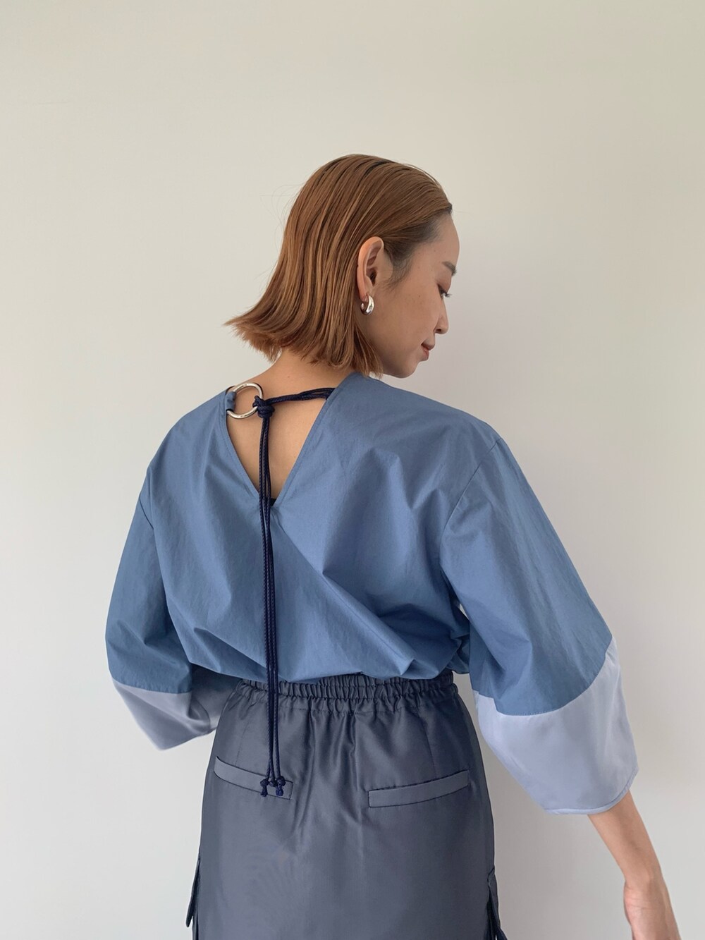 ブラック系のパンプス、ブルー系のスカート、ブルー系のシャツ/ブラウスを着用したレディースの春コーディネートの7枚目の写真