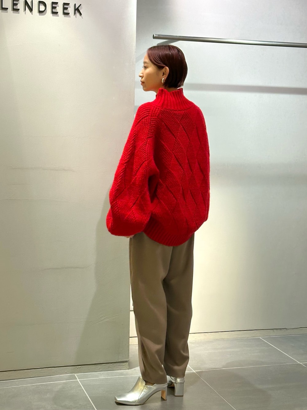 レッド系のニット/セーター、ブラウン系のその他パンツ、シルバー系のブーツを着用したレディースの秋コーディネートの4枚目の写真